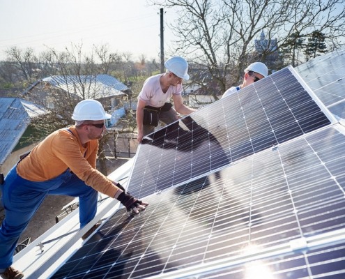 Lavoratori che installano un sistema di pannelli solari fotovoltaici. Elettricisti che montano il modulo solare sul tetto della casa moderna. Concetto ecologico di energia alternativa.